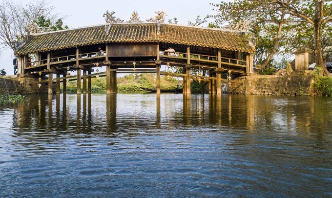 Cầu ngói Thanh ToànCầu ngói Thanh Toàn nằm ở làng Thanh Thủy Chánh, xã Thủy Thanh, thị xã Hương Thủy. Công trình này làm bằng gỗ, kiến trúc theo kiểu "thượng gia, hạ kiều", tức trên nhà dưới cầu, dài hơn 18 m, rộng gần 6 m. Đây là một trong số ít cây cầu với kiểu kiến trúc này còn tồn tại đến ngày nay ở Việt Nam. Cây cầu cách trung tâm thành phố chừng 8 km. Bạn có thể đi trước để dành thời gian chiều nghỉ ngơi ở thôn Vĩ Dạ. Ảnh: Thanh Toàn.