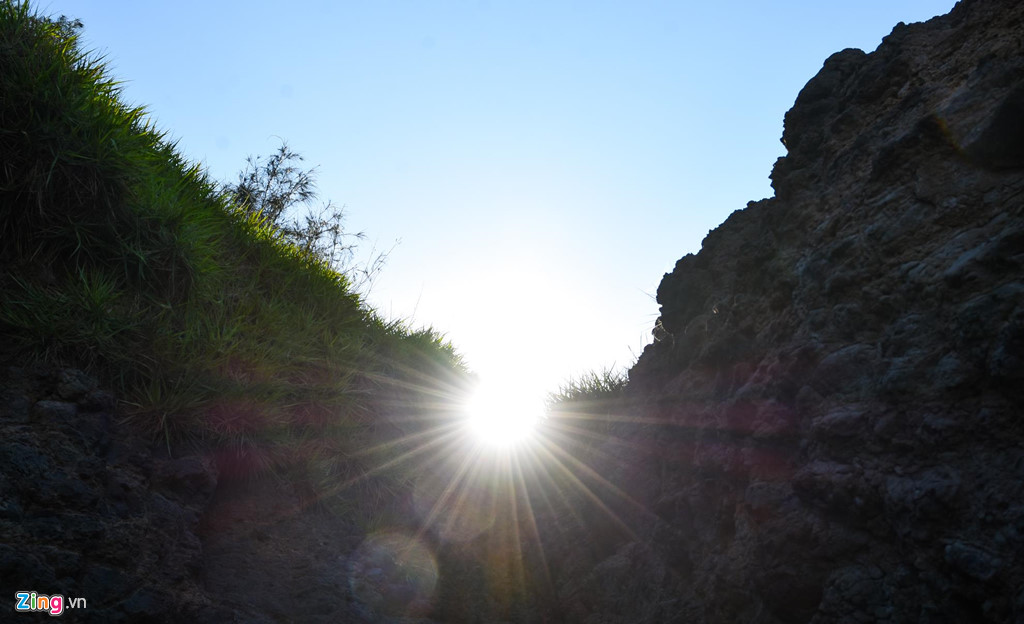 Mặt trời tỏa ánh hào quang giữa vách đá trầm tích núi lửa triệu năm. 