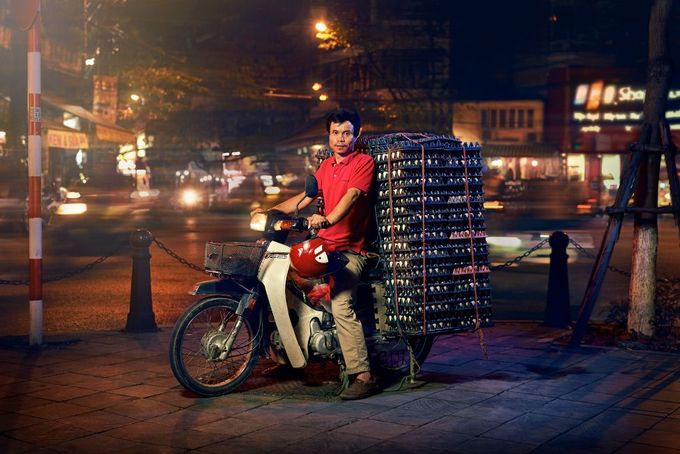 Ở Hà Nội, xe máy có nhiều vai trò, vừa là phương tiện giao thông cho gia đình, đồng thời cũng giúp vận chuyển những thùng hàng được xếp cao chót vót.