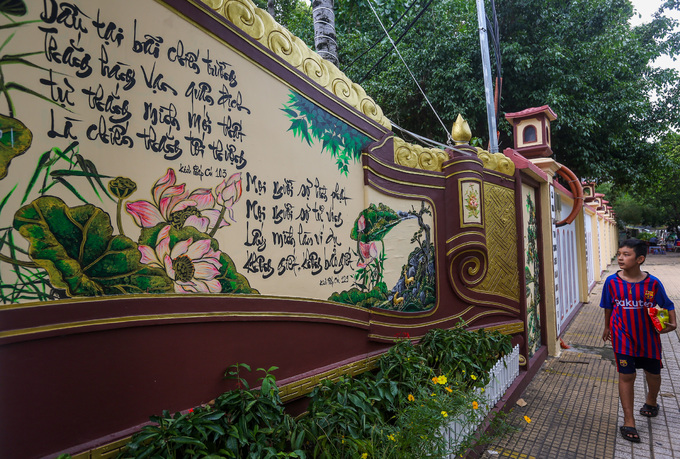 Tường bên ngoài cổng chùa Pháp Vân khá cao, trang trí bằng những câu đối, bức tranh chủ đề Phật giáo.
